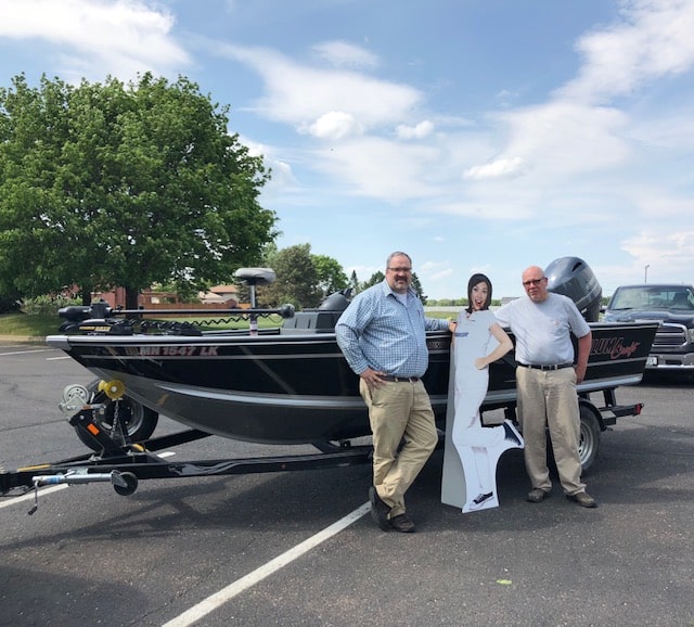 two men in front of a boat with flo from progressive