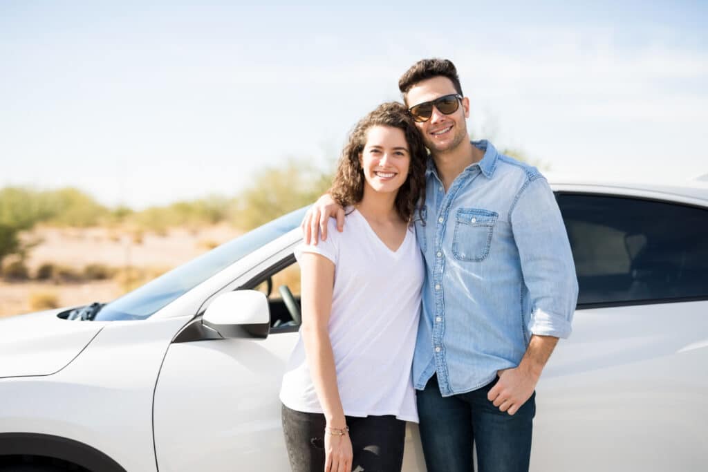Couple on road trip standing by the car