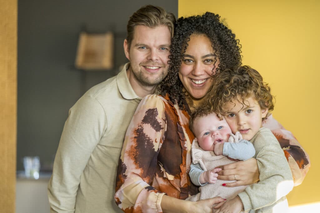 Happy family embracing at home with a warm smile.